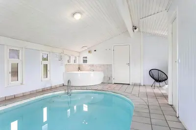 a bathroom with a swimming pool and a tub at LK1892-Lokken-Marthinesvej-37 in Løkken