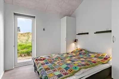 a bedroom with a bed and a large window at LK1824-Lokken-Marthasvej-16 in Løkken