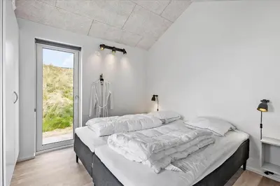 a white bedroom with a large bed with a window at LK1824-Lokken-Marthasvej-16 in Løkken
