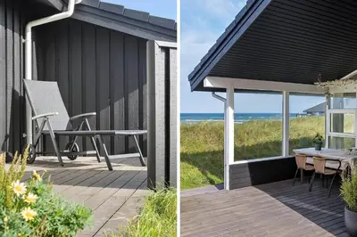 a house with a table and a chair on a deck at LK1054-Lokken-Lottesvej-22 in Løkken