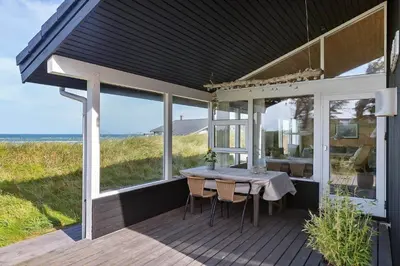 a table on a deck with a view of the ocean at LK1054-Lokken-Lottesvej-22 in Løkken