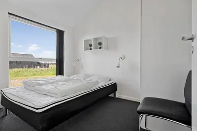 a bed in a room with a window at LK1979-Lokken-Kringelbaekvej-42 in Løkken
