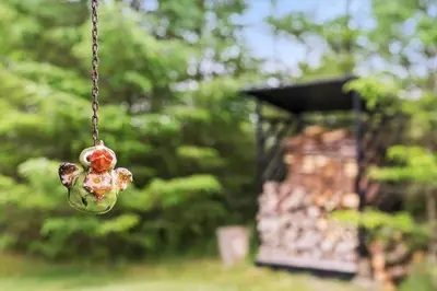 a glass jar hanging from a chain with a building in the background at LK1999-Lokken-Magdalenevej-35 in Løkken