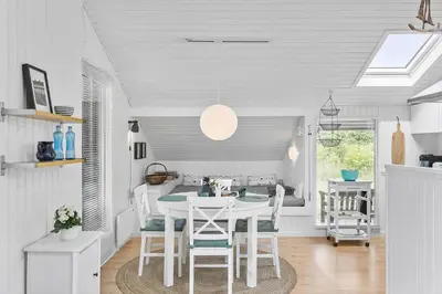 a dining room with a white table and chairs at LK1999-Lokken-Magdalenevej-35 in Løkken
