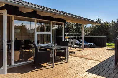a patio with a table and chairs on a deck at LK2095-Lokken-Mievej-28 in Løkken