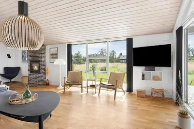 a living room with a tv and a table and chairs at LK2095-Lokken-Mievej-28 in Løkken