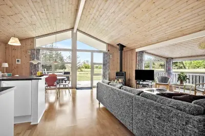 a large living room with a couch and a kitchen at LK350-Lokken-Piasvej-11 in Løkken