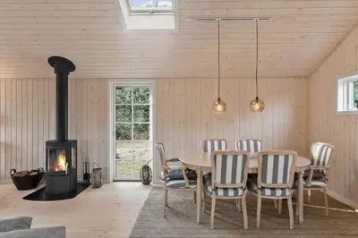 a dining room with a table and a wood stove at LK1394-Lokken-Lisevej-5 in Løkken