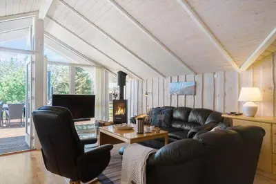 a living room with a leather couch and a tv at LK1804-Lokken-Kristavej-43 in Løkken