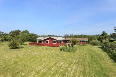 a red house in the middle of a field at LK1935-Lokken-Pernillevej-17 in Løkken