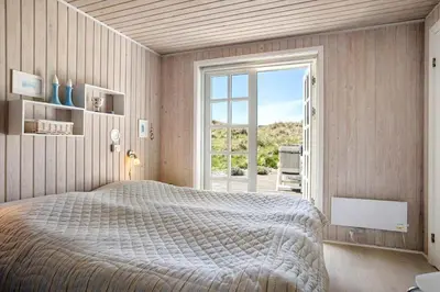 a bedroom with a large bed and a large window at LK344-Lokken-Ragnhildsvej-3 in Løkken
