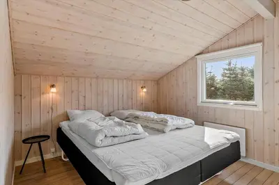 a bedroom with a bed in a room with a window at LK780-Lokken-Margrethevej-4 in Løkken