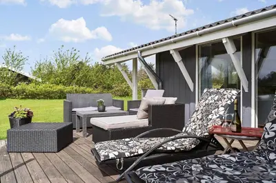 a deck with chairs and a table and a patio at LK2046-Lokken-Kristavej-25 in Løkken