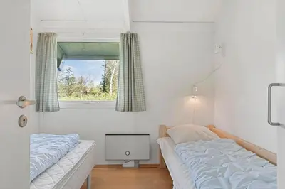 a bedroom with two twin beds and a window at LK2046-Lokken-Kristavej-25 in Løkken