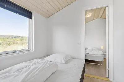 a white bedroom with a bed and a window at LK281-Lokken-Lonesvej-5 in Løkken