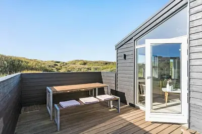a wooden deck with a bench and a table at LK281-Lokken-Lonesvej-5 in Løkken