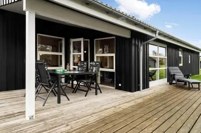 a patio with a table and chairs on a deck at LK1325-Lokken-Karinavej-59 in Løkken