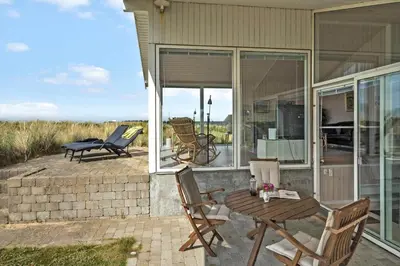 a patio with a table and chairs on a house at LK1786-Lokken-Nannasvej-18 in Løkken
