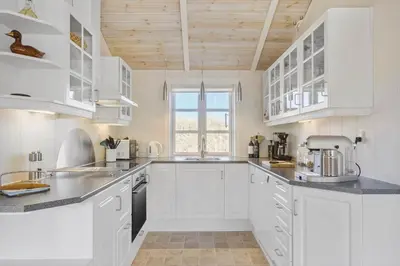 a white kitchen with white cabinets and a window at LK322-Lokken-Ornegaardsvej-27 in Løkken
