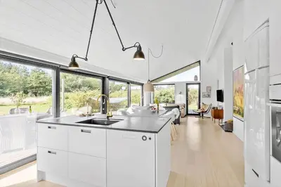 a kitchen with white cabinets and a large window at LK1946-Lokken-Kringelbaekvej-5 in Løkken