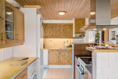 a large kitchen with wooden cabinets and counters at LK561-Lokken-Lisbethsvej-1 in Løkken