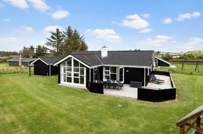 a black and white house with a large yard at LK310-Lokken-Magdalenevej-39 in Løkken