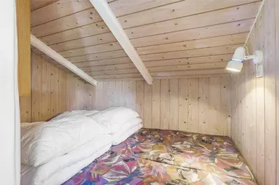 a bed in a room with a wooden ceiling at LK1641-Lokken-Karinavej-3 in Løkken