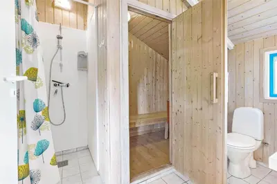 a wooden bathroom with a toilet and a shower at LK1641-Lokken-Karinavej-3 in Løkken
