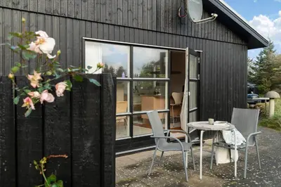 a house with a table and chairs in front of it at LK2115-Lokken-Marthasvej-7 in Løkken