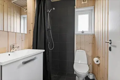 a bathroom with a toilet and a sink and a shower at LK167-Lokken-Kringelbaekvej-43 in Løkken