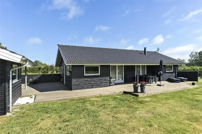 a house with a wooden deck in the yard at LK902-Lokken-Mievej-42 in Løkken