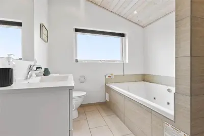 a bathroom with a tub and a toilet and a sink at LK902-Lokken-Mievej-42 in Løkken