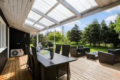 a patio with a table and chairs on a deck at LK564-Lokken-Piasvej-17 in Løkken