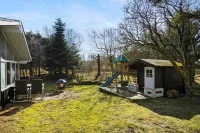 a backyard with a play house and a playground at LK564-Lokken-Piasvej-17 in Løkken