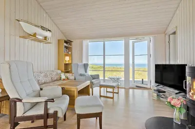 a living room with a couch and a tv at LK528-Lokken-Rosavej-5 in Løkken