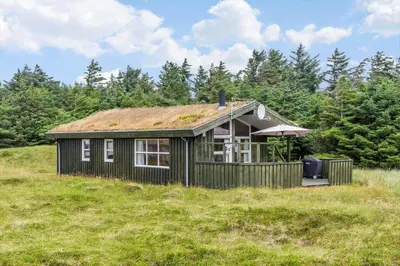 a small house with a grass roof on a hill at LK248-Lokken-Sinnesvej-43 in Løkken