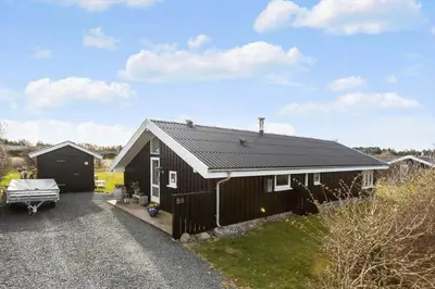 a black house with a garage and a driveway at LK847-Lokken-Odavej-59 in Løkken