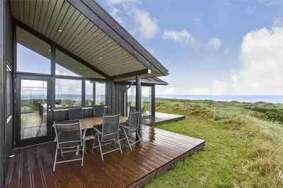 a house with a table and chairs on a deck at LK1280-Lokken-Kettrup-Bjerge-Vej-98 in Løkken
