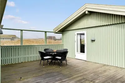 a patio with two chairs and a table on a deck at LK784-Lokken-Sinnesvej-7 in Løkken