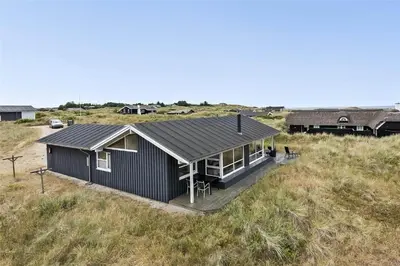 a black house sitting on top of a field at LK1179-Lokken-Normasvej-6 in Løkken