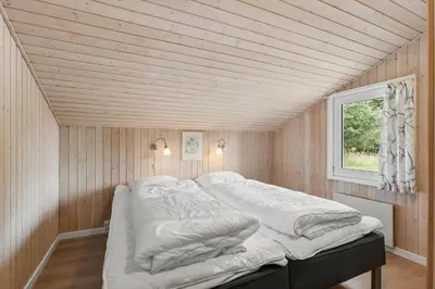 a white bed in a room with a window at LK2084-Lokken-Margrethevej-76 in Løkken