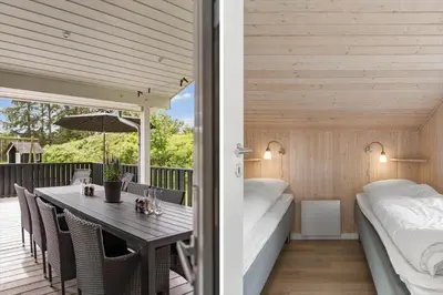 a room with a table and a bed on a deck at LK2084-Lokken-Margrethevej-76 in Løkken