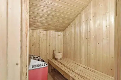 a wooden sauna with a bench and a bucket at LK626-Lokken-Magdalenevej-40 in Løkken