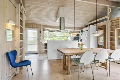 a dining room with a wooden table and chairs at LK626-Lokken-Magdalenevej-40 in Løkken