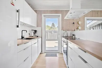 a kitchen with white cabinets and a large window at LK1779-Lokken-Lydiavej-2 in Løkken