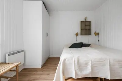 a white bedroom with a bed and a wooden floor at LK2033-Lokken-Madsinesvej-13 in Løkken