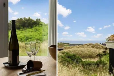 a bottle of wine sitting on a table with a glass at LK2033-Lokken-Madsinesvej-13 in Løkken
