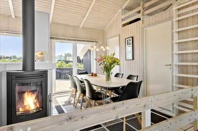 a dining room with a fireplace and a table and chairs at LK431-Lokken-Kettrup-Bjerge-Vej-62 in Løkken