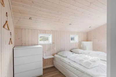 a bedroom with two beds in a room with wooden walls at LK2112-Lokken-Kettrup-Bjerge-Vej-64 in Løkken