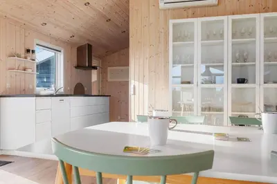 a kitchen with a white table and chairs in a room at LK2112-Lokken-Kettrup-Bjerge-Vej-64 in Løkken